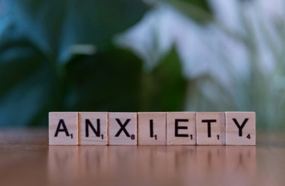 A wooden block spelling the word anxiety on a table