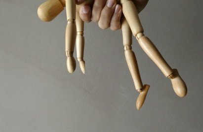 person holding brown wooden mannequin